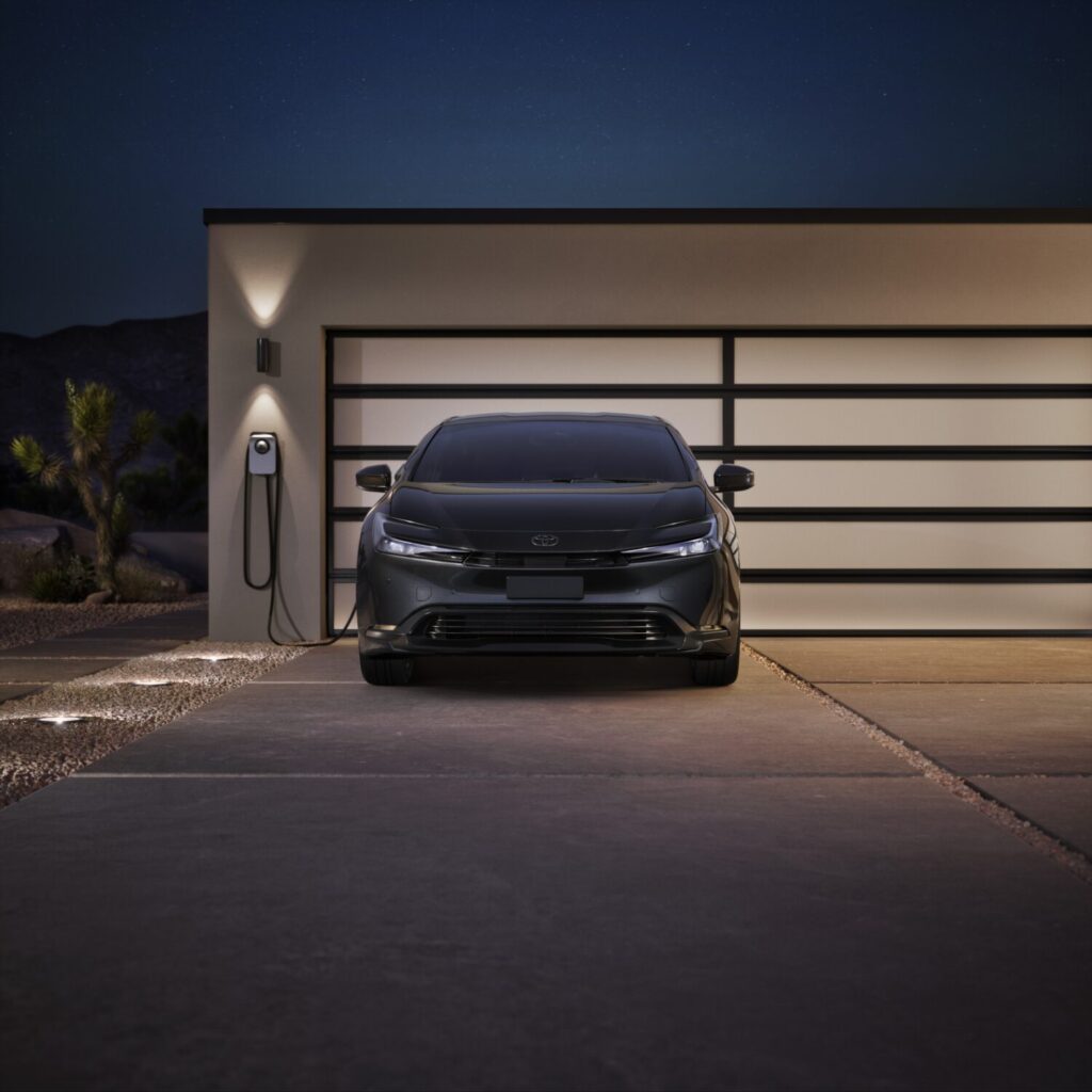 Toyota Prius Plug-in Hybrid Nightshade Edition charging outside a garage at night