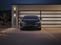 Toyota Prius Plug-in Hybrid Nightshade Edition charging outside a garage at night