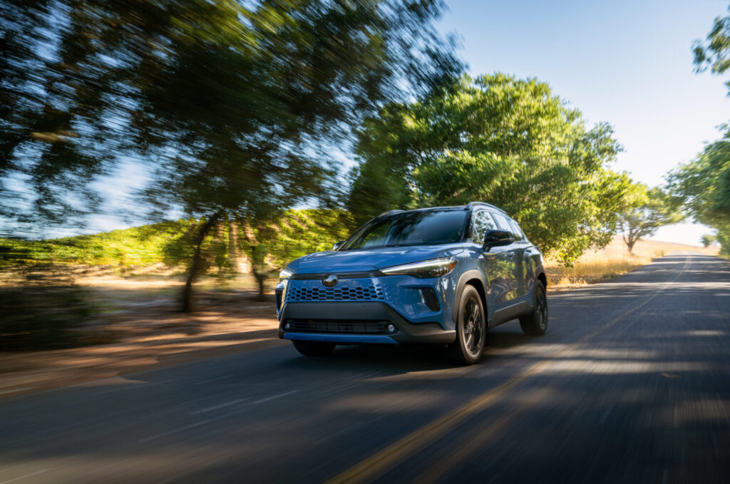 Toyota Corolla Cross Hybrid XSE AWD in Cavalry Blue on a tree-lined road