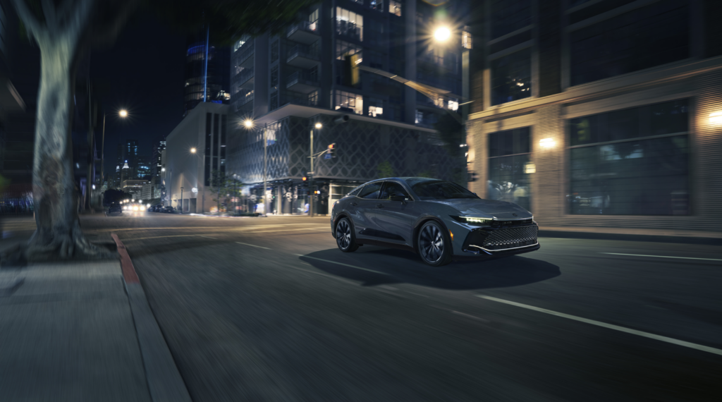 2027 Toyota Crown driving through a city at night